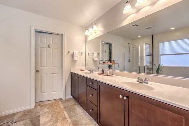 full bathroom with double vanity, a sink, visible vents, and a shower stall