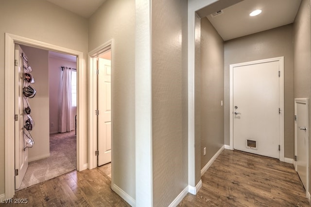 hall featuring recessed lighting, wood finished floors, visible vents, and baseboards