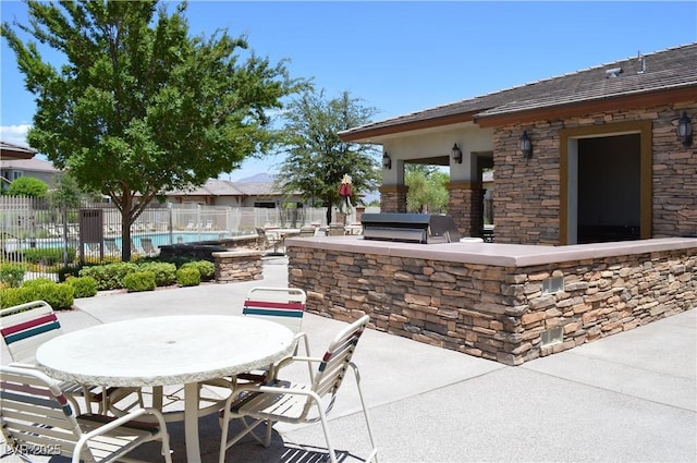 view of patio / terrace with grilling area, fence, and an outdoor kitchen