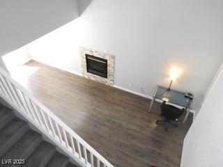 living area featuring dark wood-type flooring, a fireplace, baseboards, and stairs