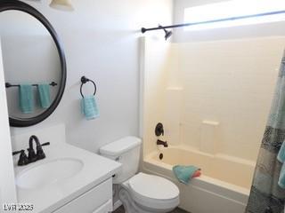 bathroom featuring shower / tub combo, vanity, and toilet