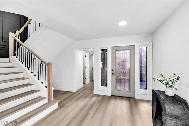 foyer with recessed lighting, stairway, and light wood finished floors