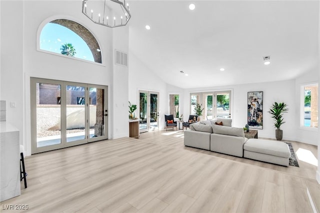 living room with light wood-style floors, visible vents, and french doors