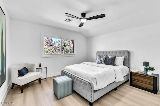 bedroom with light wood finished floors, visible vents, a ceiling fan, vaulted ceiling, and baseboards