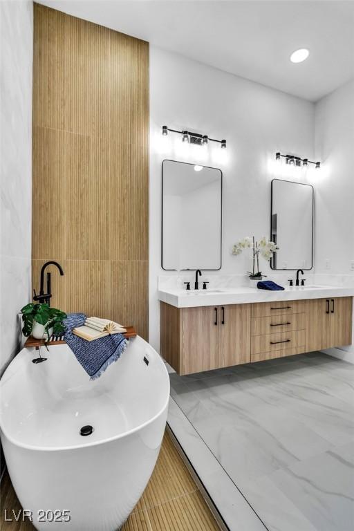 full bath with a freestanding tub, a sink, and double vanity