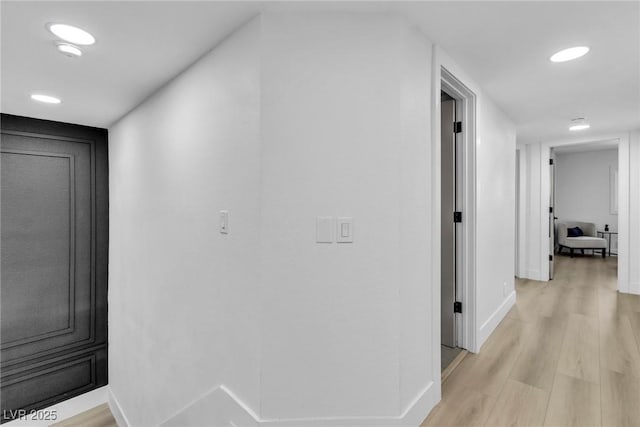 hall with baseboards, recessed lighting, and light wood-style floors