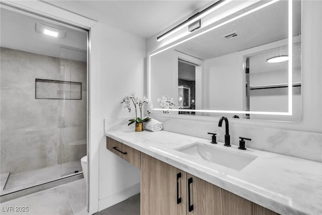 bathroom with a shower stall, visible vents, vanity, and toilet