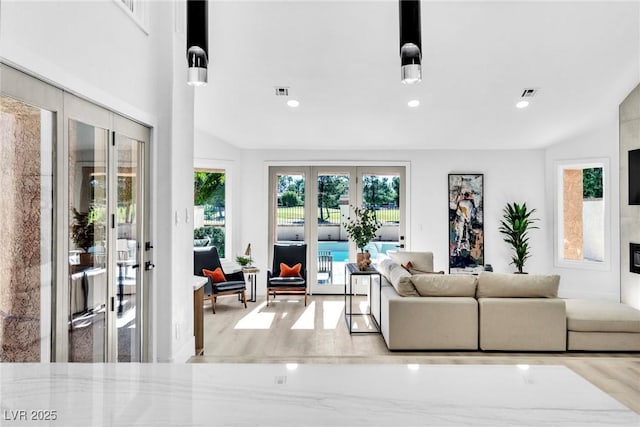 living area featuring french doors, light wood-style flooring, visible vents, and recessed lighting