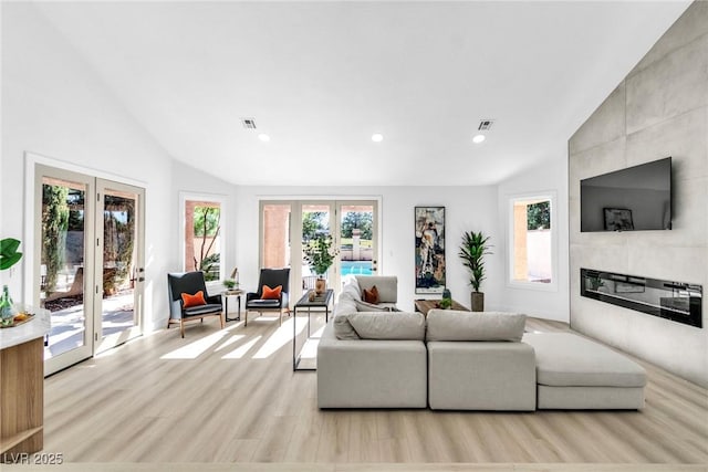 living room featuring visible vents, a tiled fireplace, french doors, light wood-type flooring, and recessed lighting