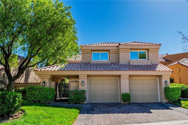 view of front facade with decorative driveway, a tile roof, an attached garage, and stucco siding