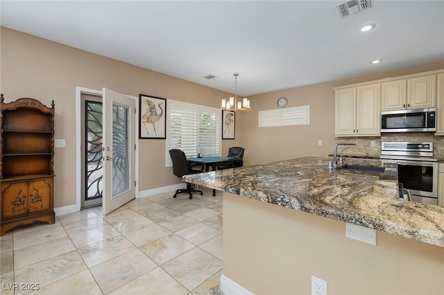 kitchen featuring visible vents, decorative backsplash, appliances with stainless steel finishes, french doors, and a sink