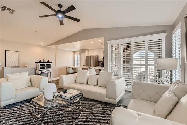 living room with lofted ceiling, baseboards, visible vents, and a ceiling fan