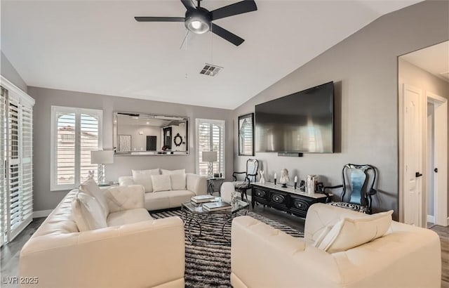 living area featuring vaulted ceiling, wood finished floors, visible vents, and a ceiling fan