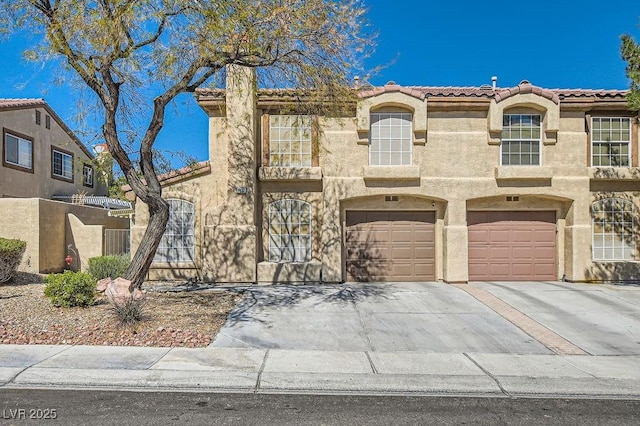 view of front of home with an attached garage, driveway, and stucco siding