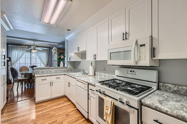 kitchen with white appliances, a ceiling fan, a sink, white cabinetry, and light wood-type flooring