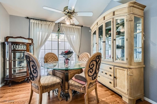 dining room with baseboards, a ceiling fan, and light wood-style floors