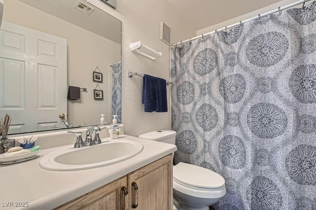 bathroom featuring visible vents, toilet, and vanity