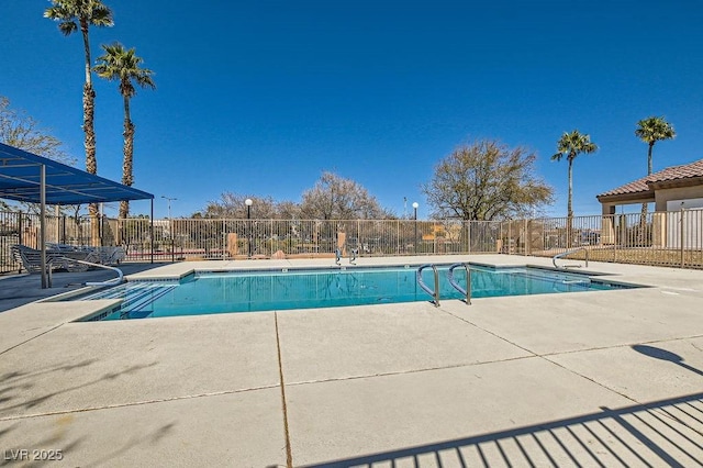 pool with a patio and fence