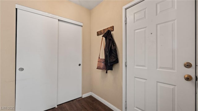 interior space with baseboards and dark wood-style flooring