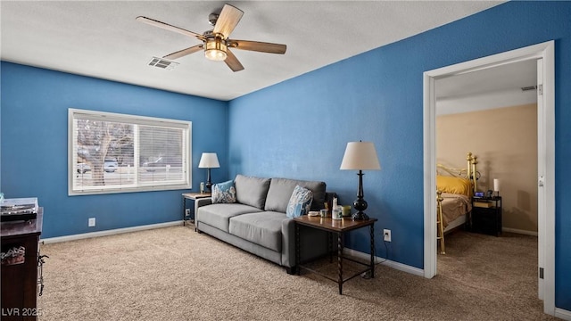 carpeted living room featuring visible vents, baseboards, and ceiling fan