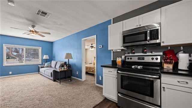 kitchen featuring stainless steel appliances, visible vents, open floor plan, and ceiling fan