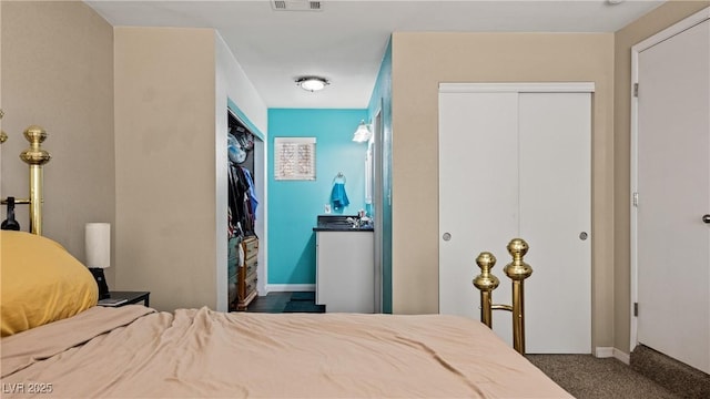 carpeted bedroom with visible vents and a closet