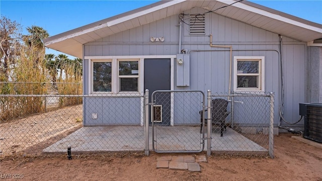 view of outbuilding with a gate, fence private yard, and cooling unit