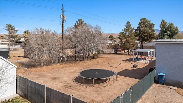 view of yard featuring a trampoline and fence