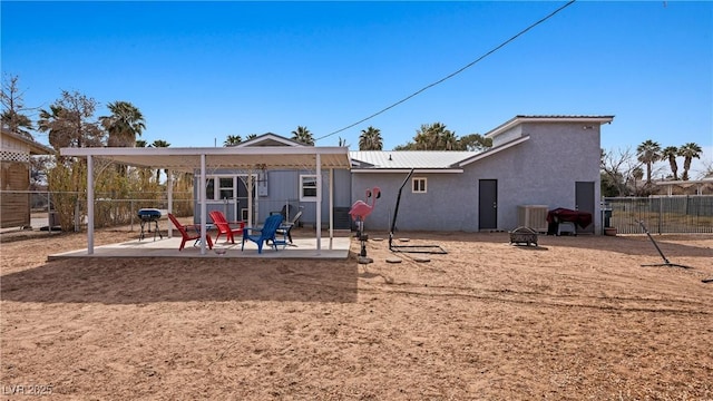 rear view of property with central air condition unit, an outdoor fire pit, fence, a patio, and stucco siding