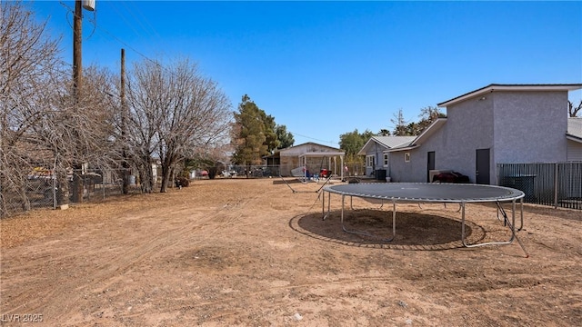 view of yard featuring fence and a trampoline