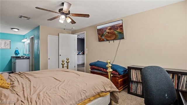 carpeted bedroom with ensuite bath, a ceiling fan, and visible vents