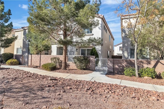 view of front of property featuring a fenced front yard, a gate, and stucco siding