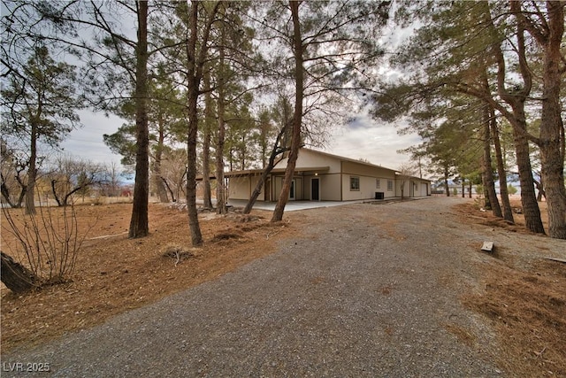 exterior space featuring an attached carport and gravel driveway