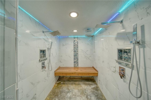 bathroom featuring unfinished concrete flooring, a tile shower, tile walls, and recessed lighting