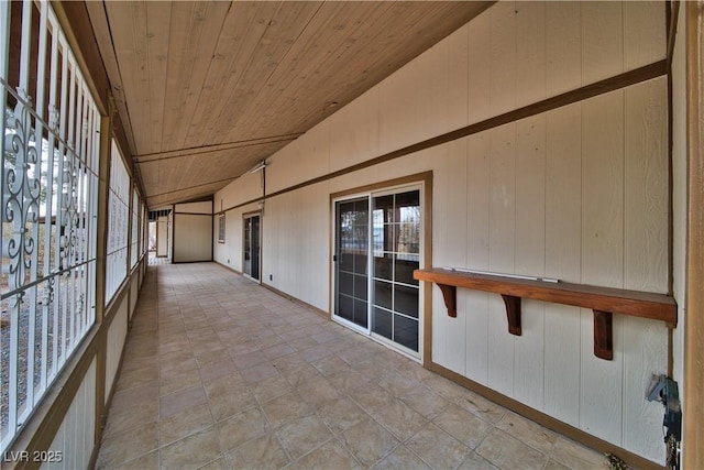 unfurnished sunroom featuring wooden ceiling and vaulted ceiling