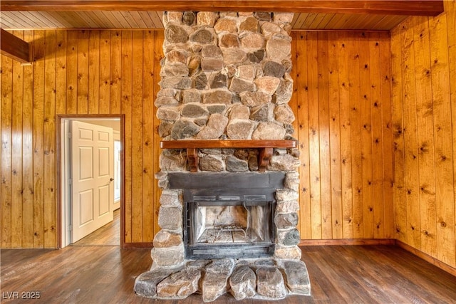 room details featuring wood ceiling, wood walls, a stone fireplace, and wood finished floors