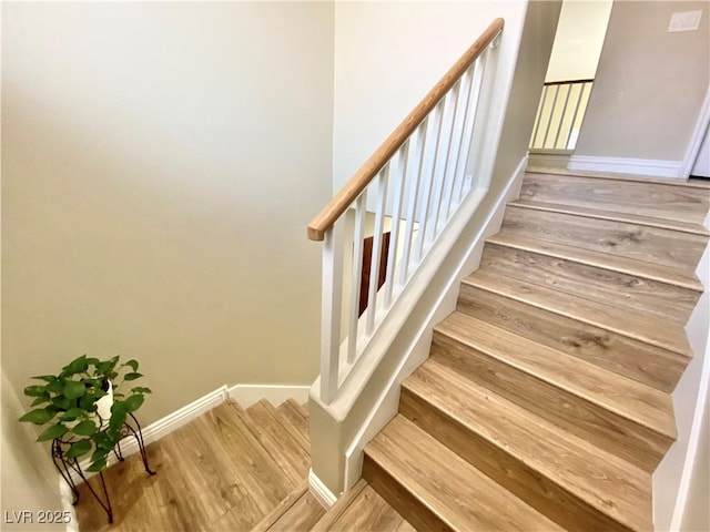 stairway featuring baseboards and wood finished floors