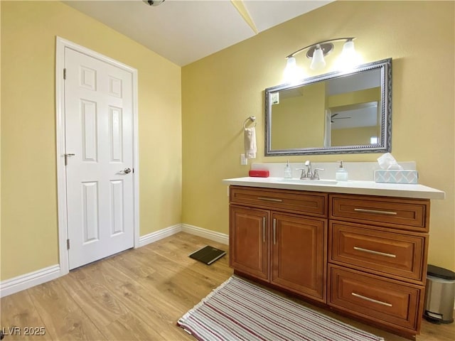 bathroom with baseboards, wood finished floors, and vanity