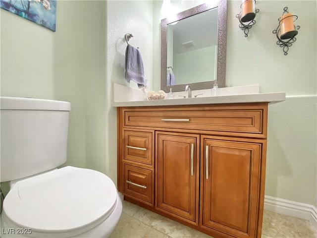 bathroom featuring tile patterned flooring, baseboards, vanity, and toilet