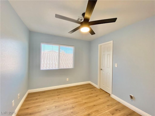 empty room with a ceiling fan, light wood-style flooring, visible vents, and baseboards