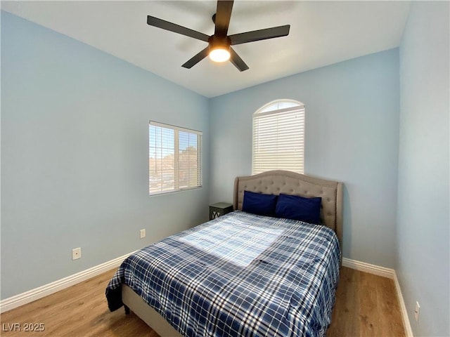 bedroom with ceiling fan, baseboards, and wood finished floors