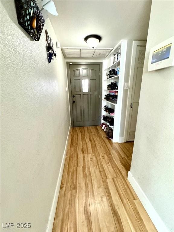 corridor featuring wood finished floors and baseboards