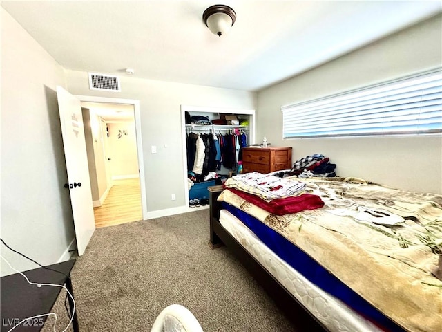 carpeted bedroom featuring a closet, visible vents, and baseboards