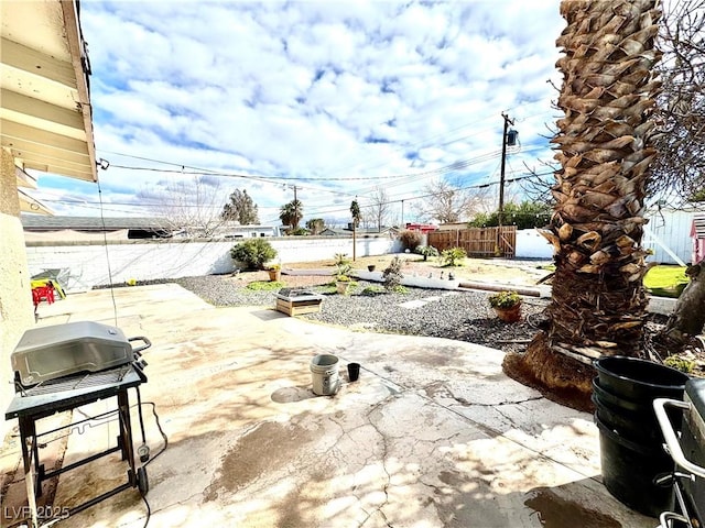 view of patio with grilling area, a fenced backyard, and a garden