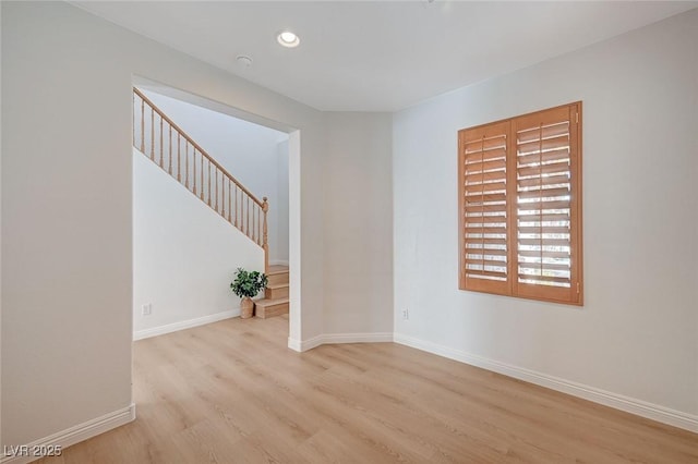 unfurnished room featuring stairs, recessed lighting, baseboards, and wood finished floors