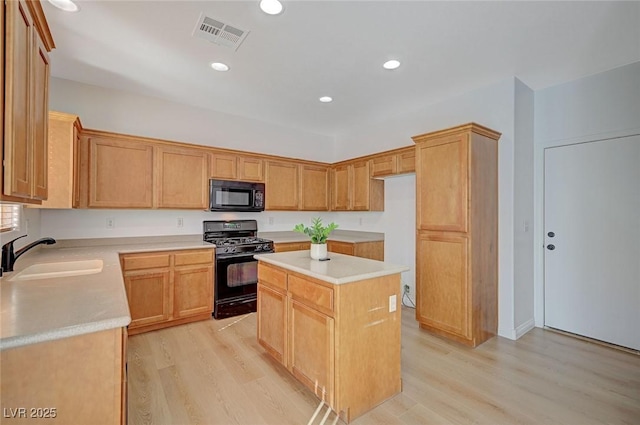 kitchen with light countertops, visible vents, a sink, light wood-type flooring, and black appliances