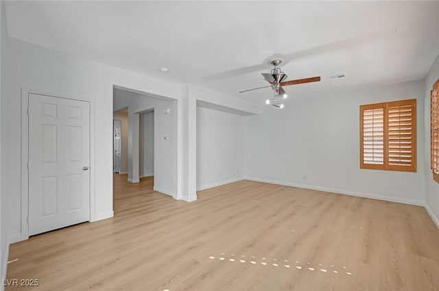 unfurnished room with visible vents, ceiling fan, light wood-style flooring, and baseboards