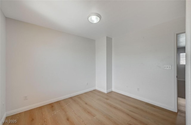 spare room with light wood finished floors and baseboards