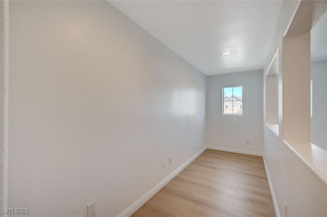 empty room with light wood-style flooring and baseboards