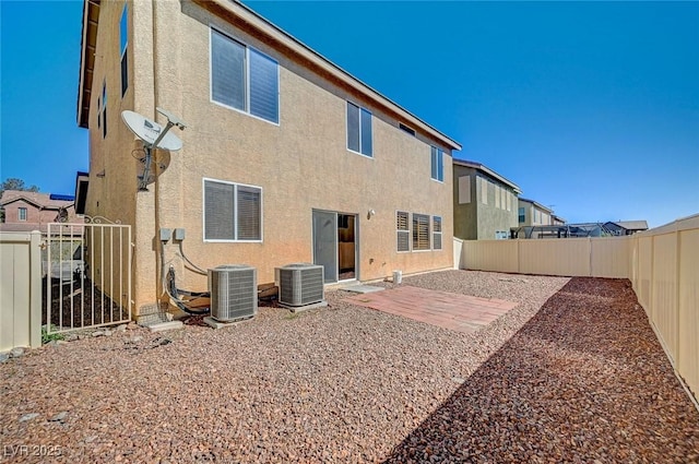 rear view of house with cooling unit, a patio area, a fenced backyard, and stucco siding